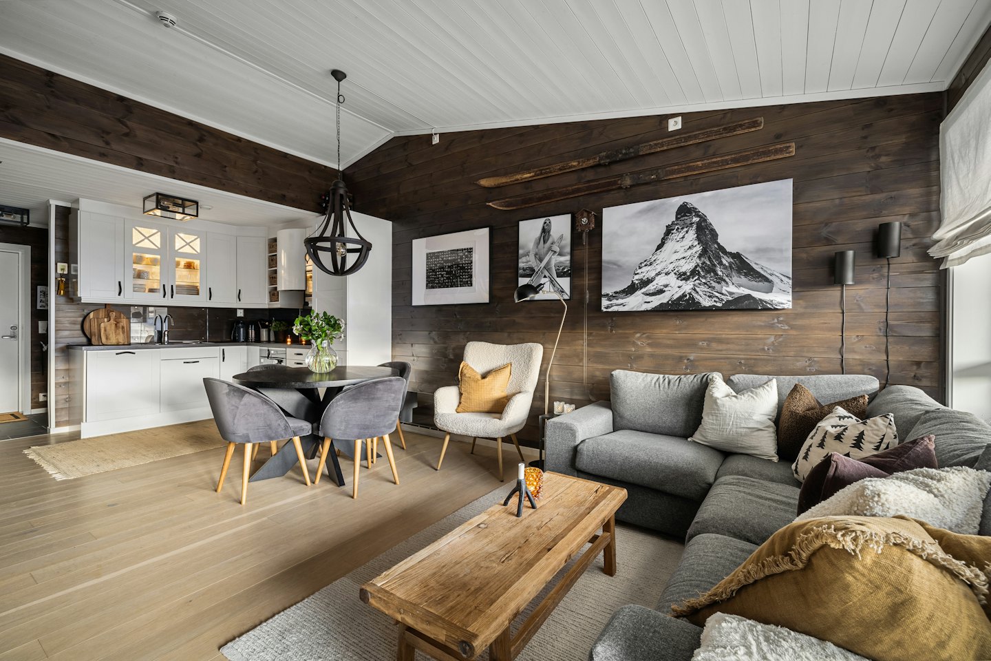 Cucina e soggiorno moderni open space con pareti in legno rustico.